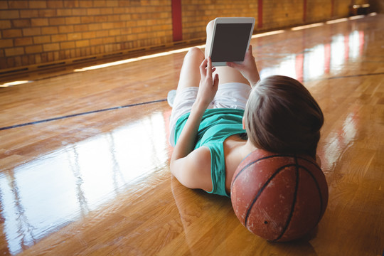 女子在篮球场躺在地板上