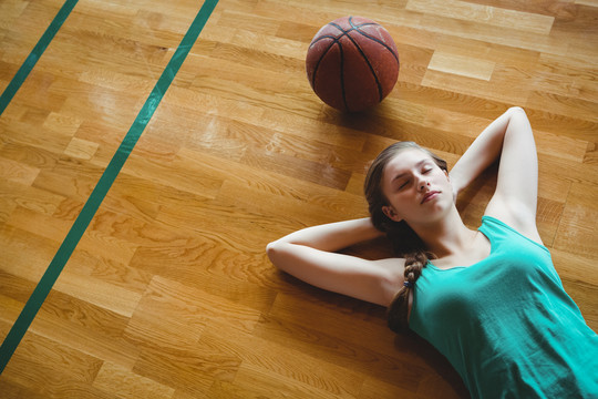 女子篮球运动员在球场上睡觉