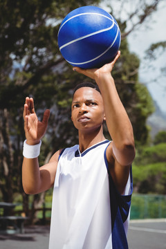 在球场上练习篮球的男青年