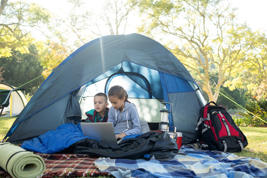 孩子们在营地帐篷里用笔记本电脑