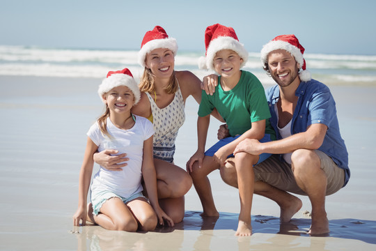 一家人戴着圣诞帽微笑的合照