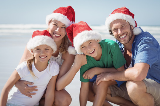 一家人戴着圣诞帽微笑的合照