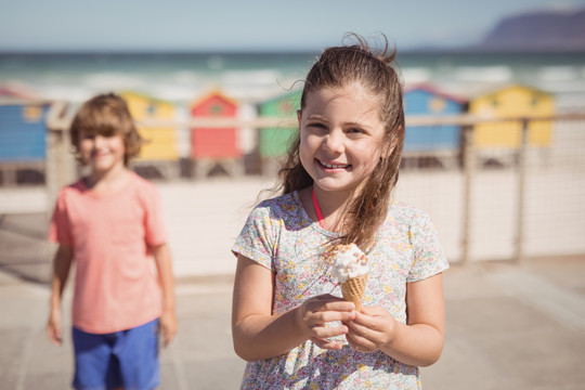 海滩上拿着冰淇淋的小女孩