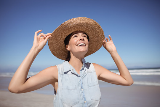 海滩上戴太阳帽的快乐女人