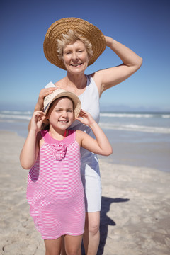海滩上带着太阳帽的外婆和女孩