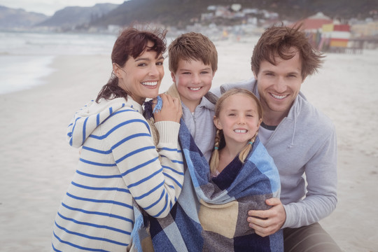 海滩上一家人一起微笑的照片