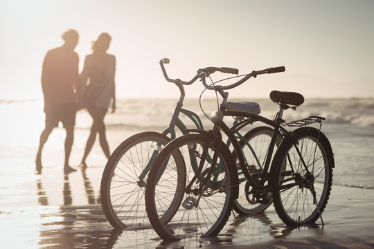 一对夫妇在沙滩上骑自行车