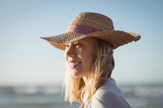 沙滩上戴着太阳帽的快乐女人