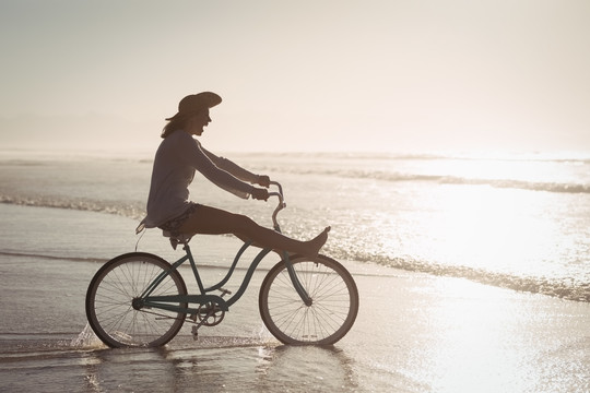 在沙滩上骑行的快乐女人