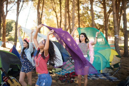 女性朋友站在野营地上拿着围巾