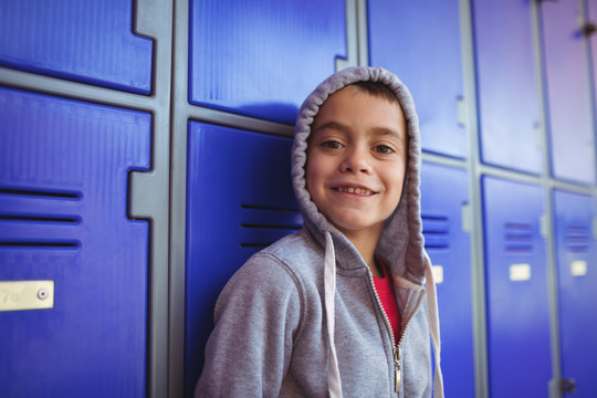 学校储物柜旁微笑男孩的画像
