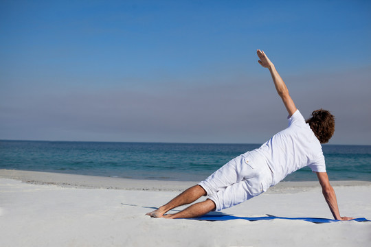 男人在海滩上练瑜伽