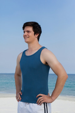 微笑的男人站在沙滩上