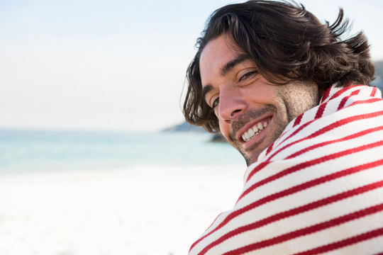 坐在沙滩上微笑的男人的肖像