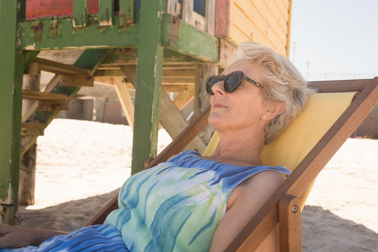海滩上带太阳镜的老妇人