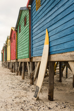 海滩沙滩上蓝色木屋旁的冲浪板