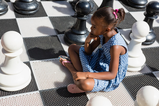 坐在棋子旁的体贴女孩