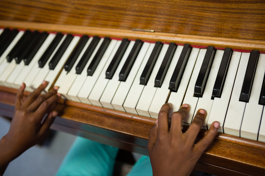 男生在学校教室练习钢琴