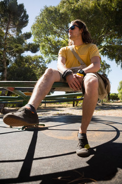 坐在公园健身器材上的年轻人