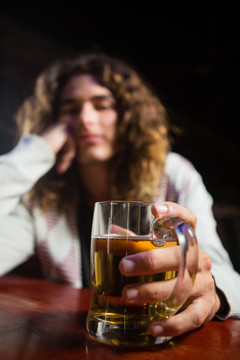 酒吧里拿啤酒杯的男人的肖像