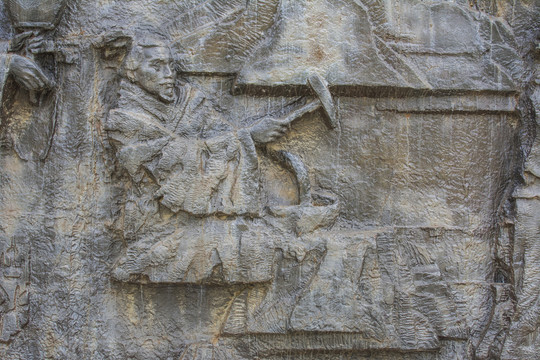 古代男人用锤锻打铁器浮雕壁雕