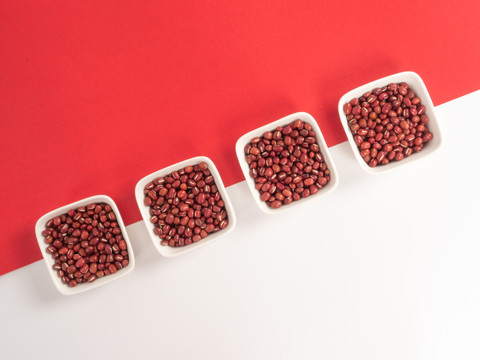 红白相间背景里的白瓷碗中的红豆