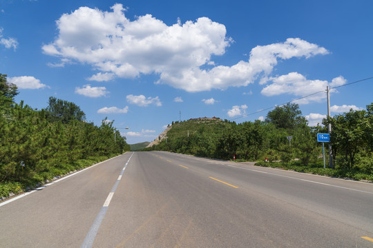 公路在蓝天白云下延伸到远方