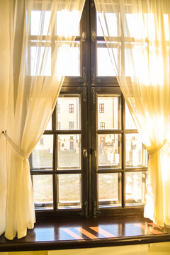阳光透过薄纱窗帘照进窗户