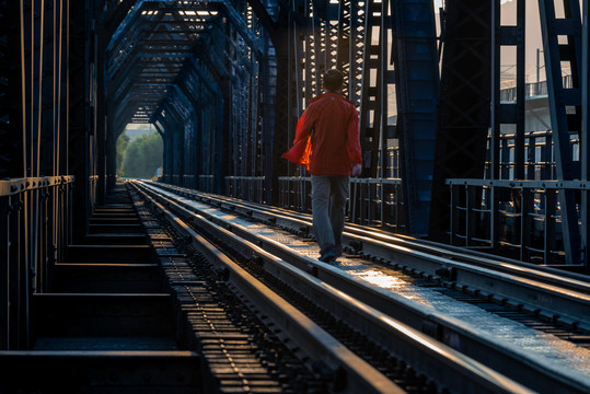 走在铁桥上的红衣男子