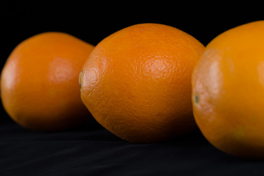黑色背景下的三个橙子