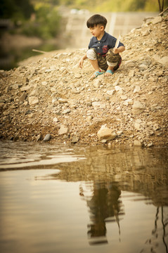 小男孩在河边玩耍