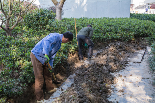 民工在建筑工地弯腰挖土