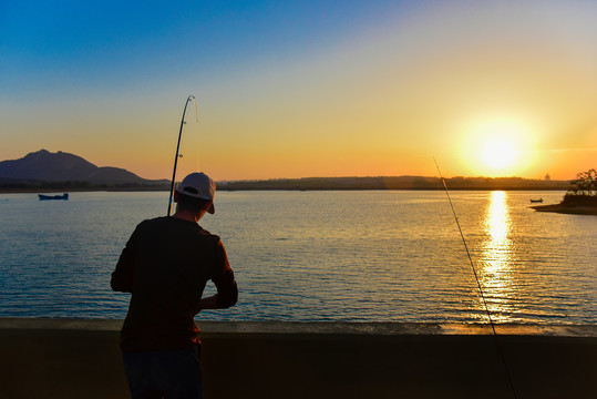 夕阳时分桥上的钓鱼人