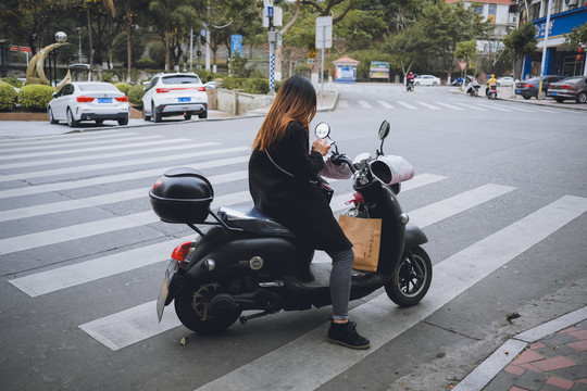 骑在电动车上的女生