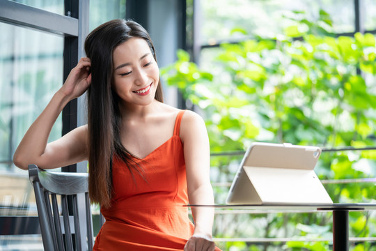 年轻女子看咖啡店使用平板电脑