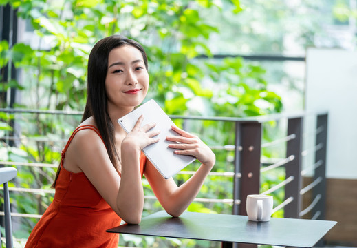 年轻女子看咖啡店使用平板电脑