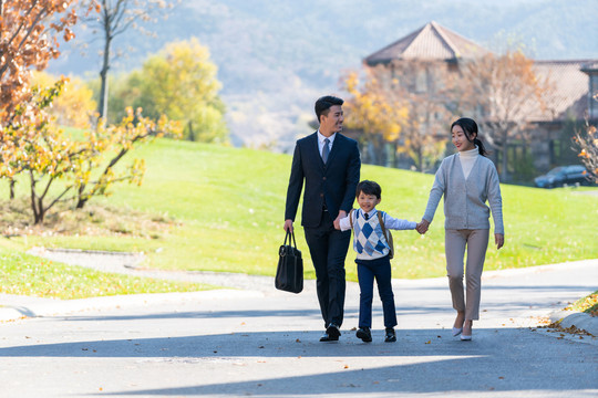 年轻夫妻送孩子去上学