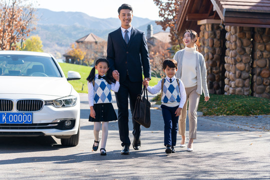 年轻夫妻送孩子去上学