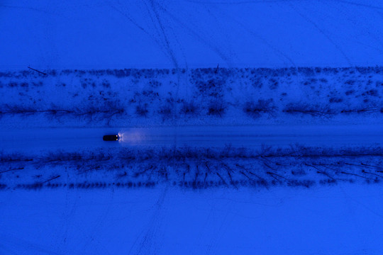 一辆越野车在雪原夜色道路上行驶