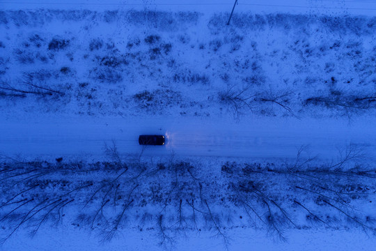 越野车在雪原夜色道路上行驶