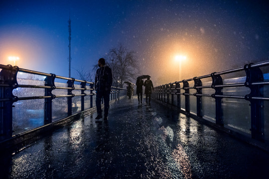 城市街道行人雪景夜晚摄影图