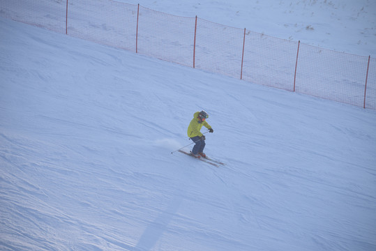 滑雪道下坡扬起雪粉的滑雪者