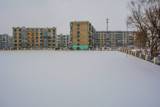 校园操场雪地与多层住宅建筑群