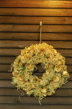 木墙上挂着干花的花圈