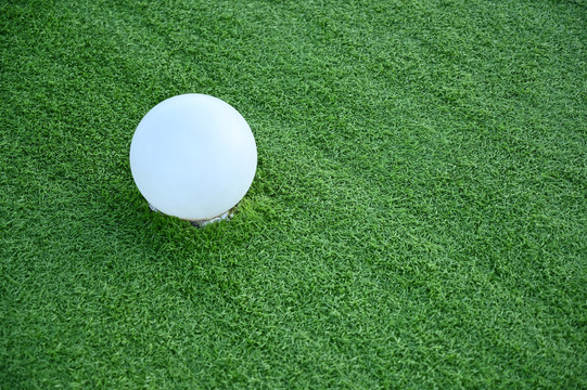绿色草坪上的白色小球