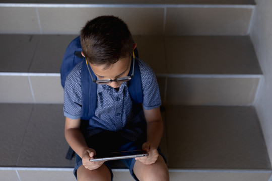 小学生坐在小学的台阶上