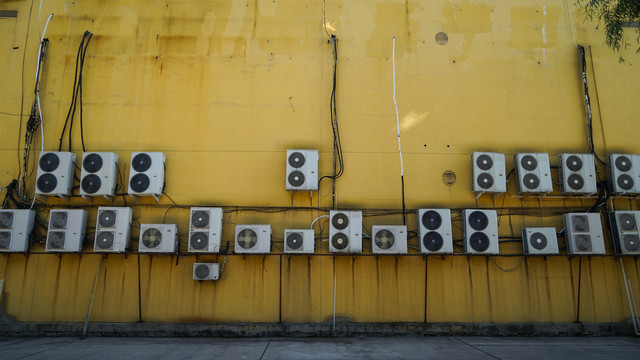 黄色墙壁上的大量空调外机