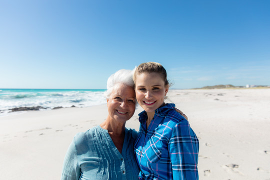 一位妇女和母亲站在海滩上的肖像
