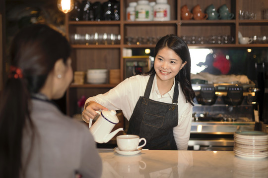 酒保往杯子里倒茶