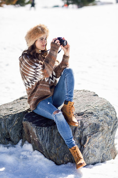 在雪山上拍照的年轻女子